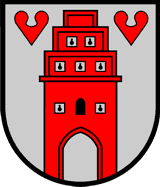 Es wird das Wappen der Stadt Friesothe dargestellt: ein rotes Stadttor auf einem silberfarbenen Schild. oben links und rechts jeweils ein rotes Herz.&nbsp;&copy;&nbsp;Stadt Friesoythe