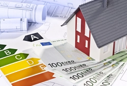 Energie Ein Model eines Wohnhauses auf einer einem Papier mit einer Energieskala
